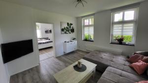 a living room with a couch and a flat screen tv at Ferienwohnung Emma s Fehnhaus, 55183 in Stickhausen +2 photos