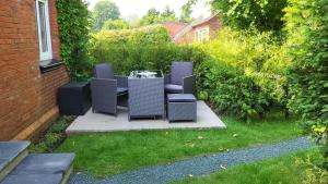a patio with chairs and a table in a yard at Ferienwohnung Emma s Fehnhaus, 55183 in Stickhausen