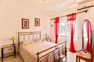 アルトゥーラにあるAlcaria Grand Houseのベッドルーム1室(赤いカーテンと窓付きのベッド1台付)