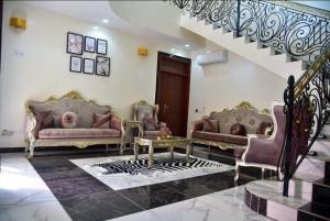 a living room with two couches and a staircase at Résidence Chérel 'NEW' in Yaoundé