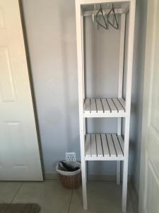 a white shelf in a room next to a door at Cottage 49 in Parys