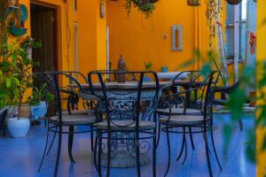 a table and chairs in front of a yellow wall at Hotel Sethi Legacy in Haridwār
