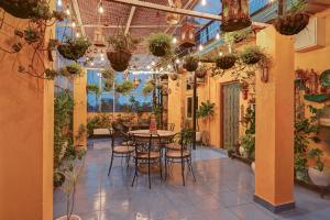 a room with a table and chairs and plants at Hotel Sethi Legacy in Haridwār