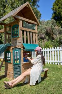 a woman sitting on a bench in a play house at Princess Resort, Santikos Collection in Agia Paraskevi