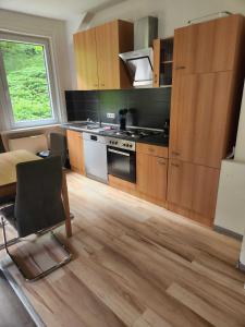 a kitchen with wooden cabinets and a table with a chair at Monteurwohnungen Lerbachtal in Osterode +30 photos