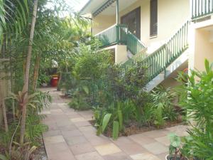 a walkway leading to a garden filled with plants at City Gardens Apartments in Darwin