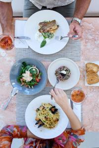 a group of people sitting at a table with plates of food at Princess Resort, Santikos Collection in Agia Paraskevi