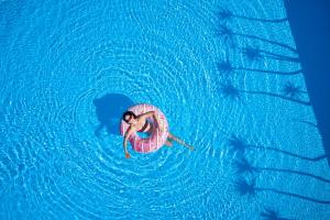 Vue de tête d'une femme dans un cercle intérieur dans l'eau dans l'établissement Princess Resort, Santikos Collection, à Agia Paraskevi