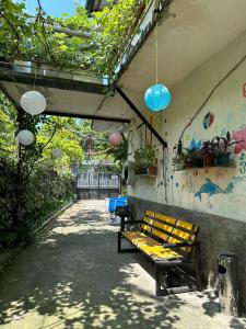 a bench sitting under a building with some lights at Guest House Barbi in Batumi