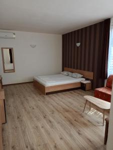 a small bedroom with a bed and a chair at Perperеshka River Villas in Stremtsi