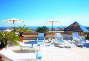 a group of chairs and tables and umbrellas on a roof at AC Hotel Genova by Marriott in Genoa