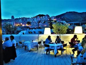 a group of people sitting at tables on a roof at AC Hotel Genova by Marriott in Genoa