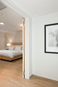 Un dormitorio con una cama y un cuadro en la pared. en Nuss Buenos Aires Soho, en Buenos Aires