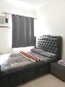 a bed sitting in a room with a window at Yumi Condotel 1 in Dumaguete