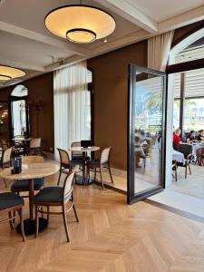 a dining room with tables and chairs and a window at Hotel Pine in Tivat