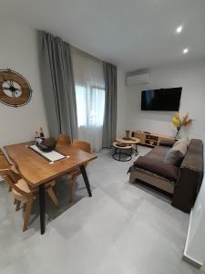 a living room with a table and a couch at Adams Apartments in Skala Rachoniou +7 photos