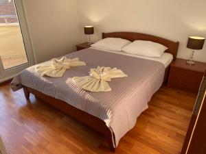 a bedroom with a bed with bows on it at Apartment Bumbar Sunset in Rogoznica