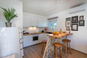 a kitchen with white appliances and a counter with stools at Casa Antonio in Anemogiannátika