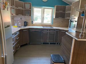 a small kitchen with wooden cabinets and a window at Beautiful Loft in Petrovac na Moru