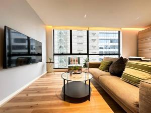 un soggiorno con un divano e un tavolo di Stylish Urban Retreat in Melbourne CBD a Melbourne