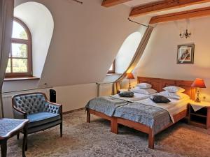 a bedroom with a bed and a chair at Dworek Kazimierski in Kazimierz Dolny +40 photos