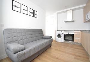 a living room with a couch and a kitchen at Apartamentos Xiana in O Grove +5 photos