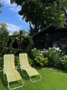 two chairs sitting in the grass in a yard at Summer chalet in the heart of Riga in Rīga +4 photos