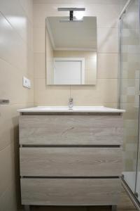 a bathroom with a sink and a mirror at Apartamentos Xiana in O Grove