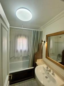 a bathroom with a sink and a mirror and a shower at Villa del Tramonto Piscina privata in Stintino