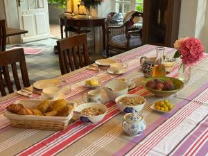 a table with a breakfast of bread and other foods at Les Jardins d'Ayaël in Ozenay