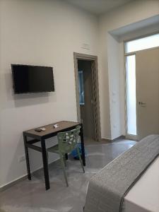 a living room with a table and a tv on the wall at B&B Carpe Diem 2 in Caserta +27 photos