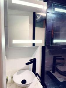 a bathroom with a white toilet and a sink at Apartamar in Suances