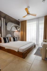 a bedroom with a large bed and a ceiling fan at Zen Vama Veche in Vama Veche +39 photos