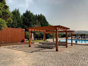 a wooden pavilion sitting next to a swimming pool at Casas do Souto in Lousada