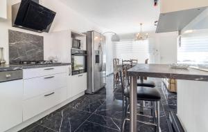 a kitchen with white cabinets and a black tile floor at 2 Bedroom Nice Home In Chateaurenard in Châteaurenard