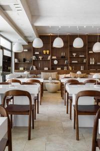 a restaurant with white tables and chairs and wooden walls at Zen Vama Veche in Vama Veche