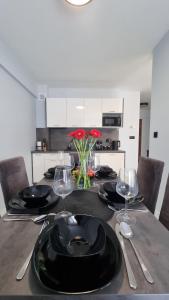 a dining room table with black plates and wine glasses at Katowice Apartamenty Hetmańska 4 in Katowice
