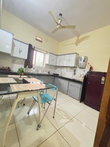 a kitchen with a table and a ceiling fan at Dream Ashoka Homestay in Ujjain