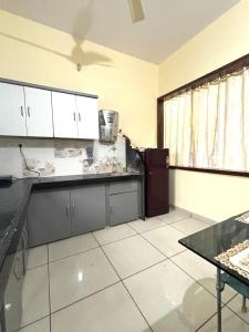 a kitchen with white cabinets and a black counter top at Dream Ashoka Homestay in Ujjain +12 photos