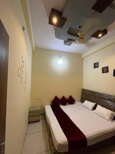 a bedroom with a large bed with red pillows at Dream Ashoka Homestay in Ujjain