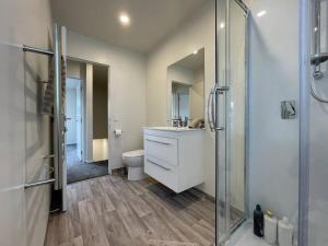 a bathroom with a shower and a sink and a toilet at CBD Luxury Parkside Living 2 Bedroom With Parking in Christchurch +41 photos