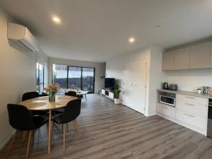 a kitchen and living room with a table and chairs at CBD Luxury Parkside Living 2 Bedroom With Parking in Christchurch