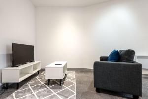 a living room with a couch and a tv and a table at Budget 1 Bed Flat in Central Doncaster in Doncaster +5 photos