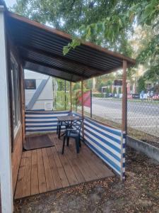a wooden deck with a picnic table under a canopy at Domek GLAMPING na Polu namiotowym RADOŚĆ in Okuninka +12 photos