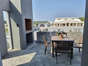 a table and chairs on a patio with a view at Mya in Agulhas