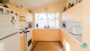 eine Küche mit weißen Schränken und einer Spüle in der Unterkunft Bromyard Cottage in Swansea