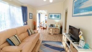 ein Wohnzimmer mit Sofa und Fernseher in der Unterkunft Bromyard Cottage in Swansea