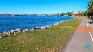 un sentiero accanto a uno specchio d'acqua con rocce di Bromyard Cottage a Swansea Altre 13 foto