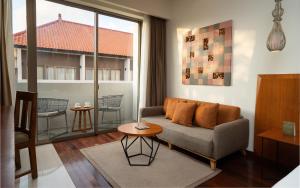 a living room with a couch and a table at MERUSAKA Nusa Dua in Nusa Dua