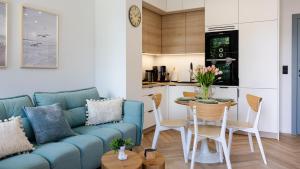 ダルウフコにあるPorto Mare, Sun & Snowの青いソファとテーブルのあるリビングルーム
